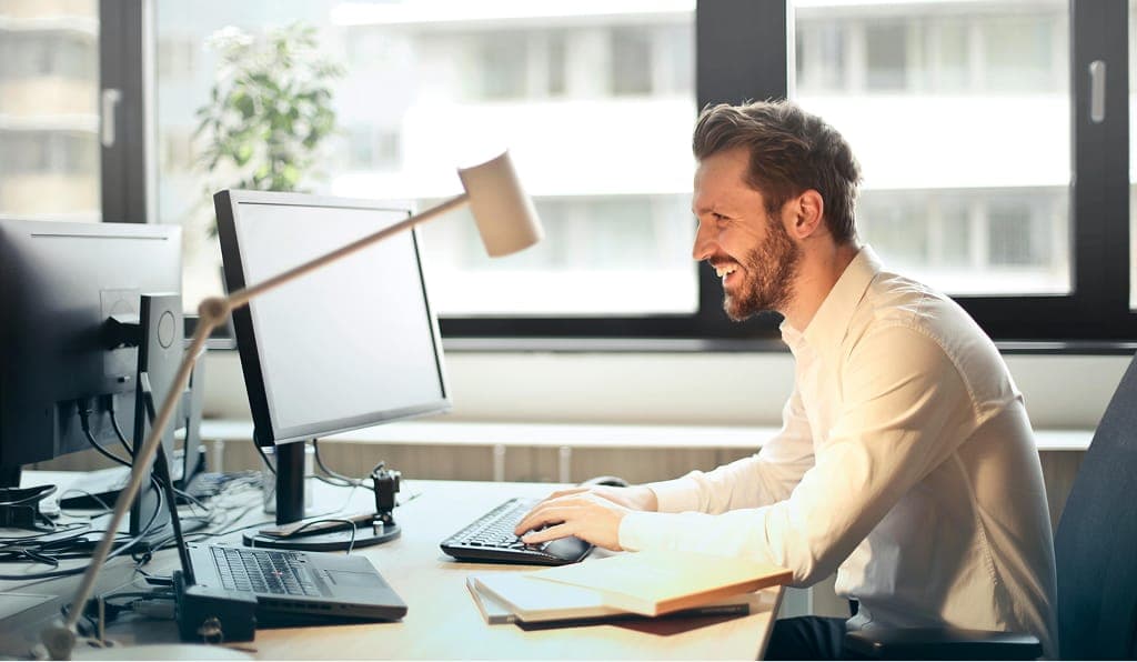 Glücklicher Makler, der am Desktop ein Video-Exposé erstellt hat